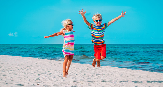 Hoppende glade barn på strand