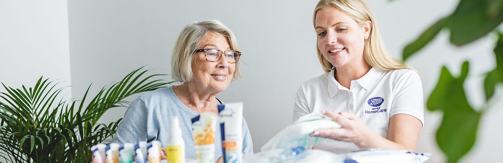 en eldre damer får hjelp av en HomeCare sykepleier med ernæring