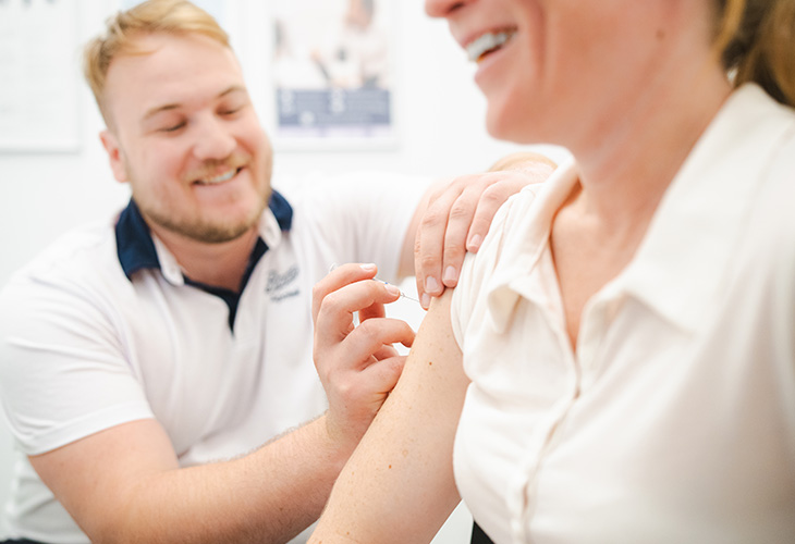 farmasøyt i apotek, hjelper deg med influensavaksine