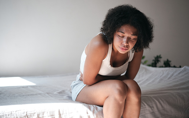 kvinne har menstruasjonssmerter pms